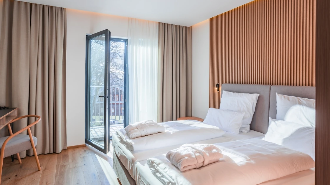 Room with a double bed and a view of the city